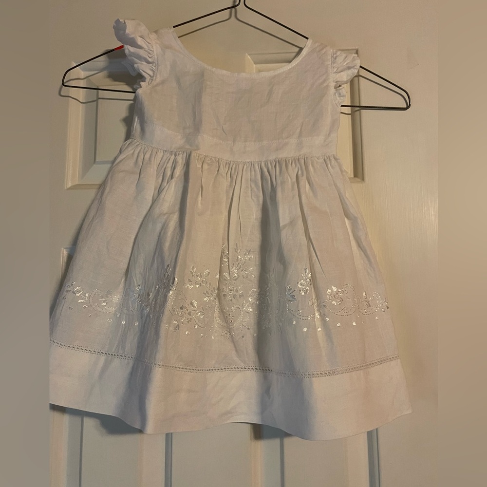 White linen dress with embroidered detail.